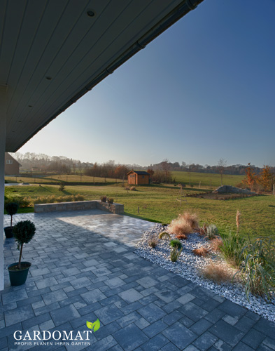 Hellgraue rechteckige Pflastersteine geben der Terrasse ein modernes Aussehen.