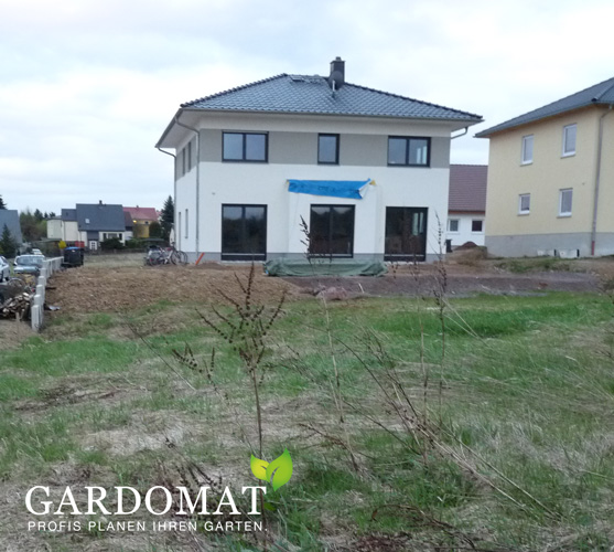 Blick über den leeren Garten zum Haus